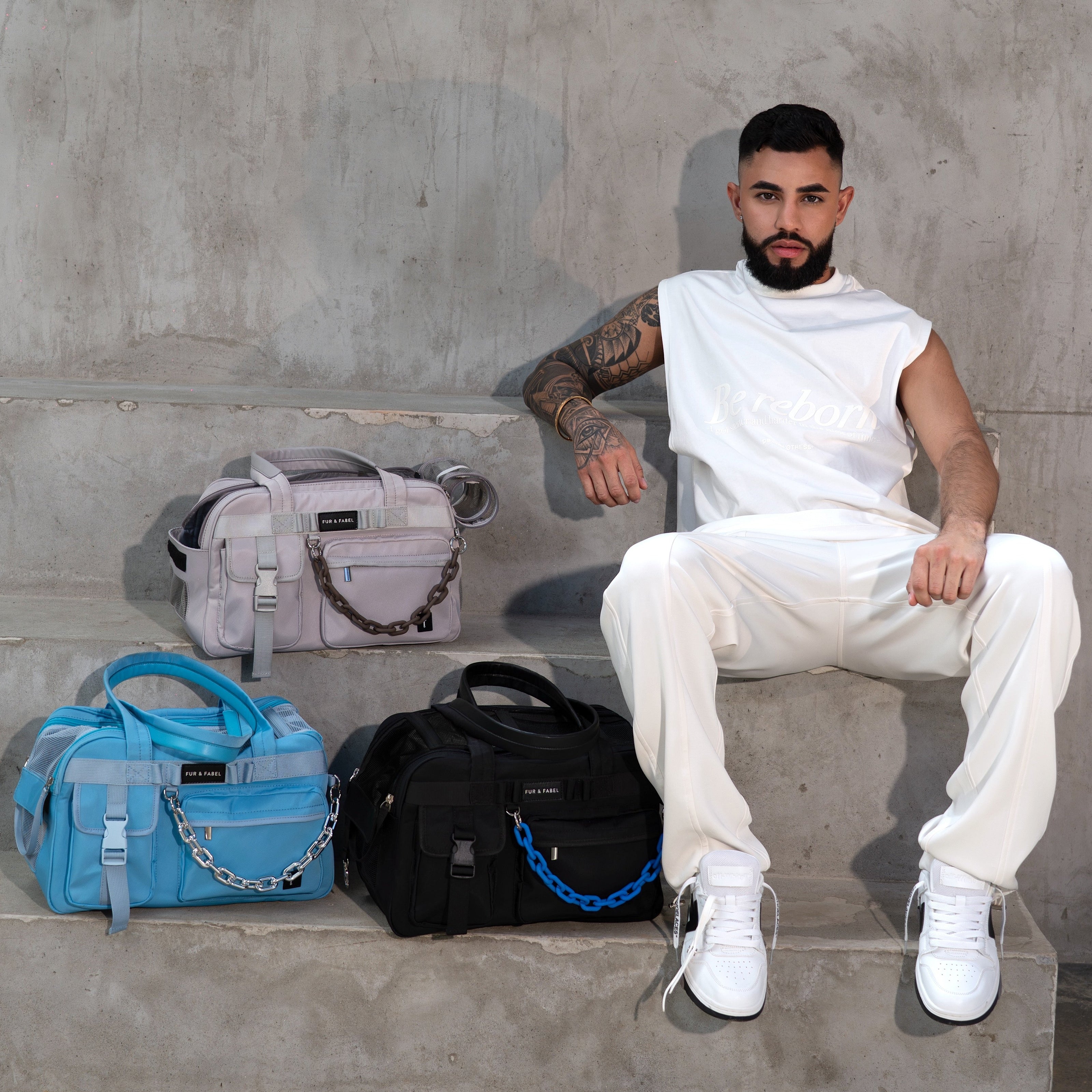 Man sitting on concrete steps with four bags in front of him.